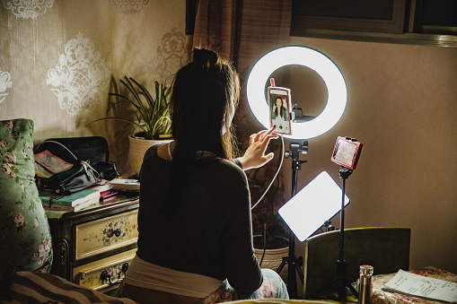 asian female influencer filming content using phone in a bedroom - Social Nation influencer categories content creator