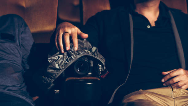 A man is secretly filming a video while watching a movie at the cinema - Social Nation piracy movie theatre cinema hall cinematograph act anti recording device phone camera film movie act bill